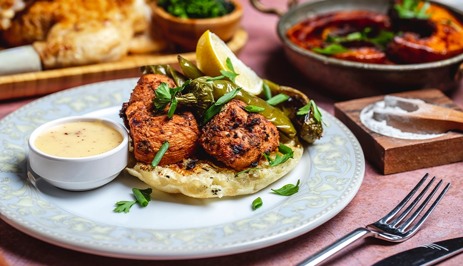 crilled-chicken-bread-piece-greens-pepper-sauce-spices-side-view